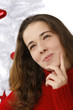 Beautiful young woman next to christmas tree on white background