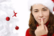 Beautiful young woman wearing santa hat next to christmas tree o