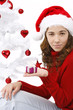 Beautiful young woman wearing santa hat next to christmas tree o