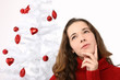 Beautiful young woman next to christmas tree on white background
