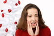Beautiful young woman next to christmas tree on white background