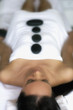 Pacific Islander woman having hot stone massage