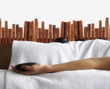 Pacific Islander woman holding hot stone in spa