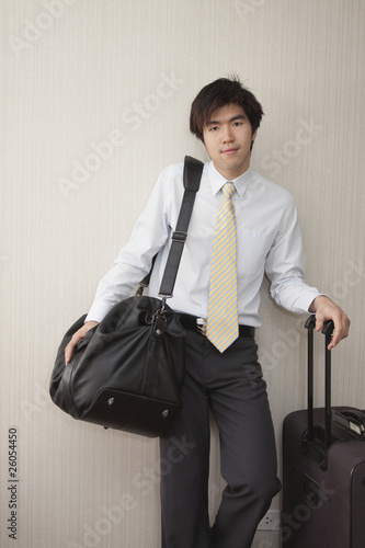 Photo: Chinese businessman standing with luggage Chinese businessman standing with luggage