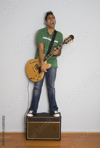 Photo: Mixed race man playing electric guitar Mixed race man playing electric guitar