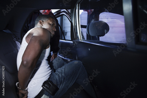 Photo: African man being placed in backseat of police car African man being placed in backseat of police car
