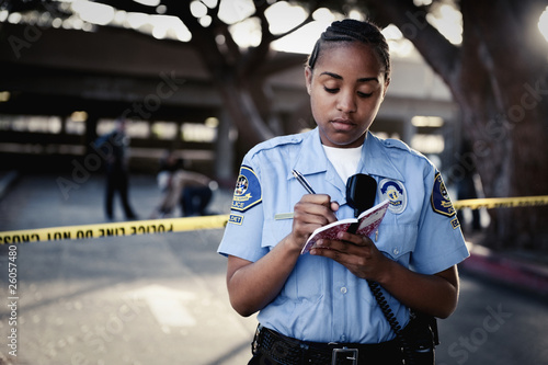 Photo: African policewoman writing in notebook African policewoman writing in notebook