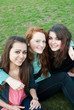 Three different girls are laying on the grass and hugging Three different girls are laying on the grass and hugging
