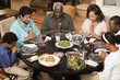 Multi-generation family saying grace at dinner table