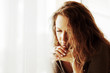 Sad woman agaist window.