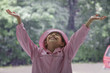 Hispanic girl standing in rain with arms raised