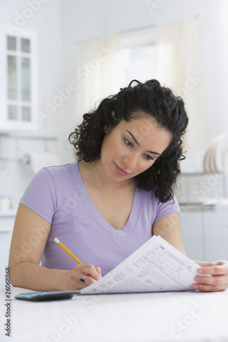 Photo: Hispanic woman completing tax forms Hispanic woman completing tax forms