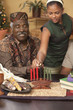 Grandfather and granddaughter lighting Kwanzaa candles