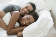 Smiling couple laying in bed