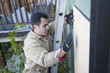 Hispanic man fixing siding of house