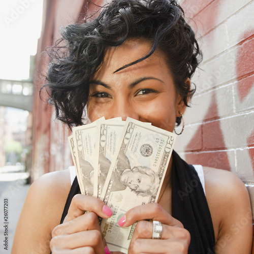 Photo: Mixed race woman holding twenty dollar bills Mixed race woman holding twenty dollar bills