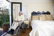 Elderly Hispanic man in wheelchair looking out window