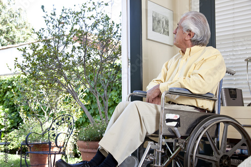 Photo: Elderly Hispanic man in wheelchair looking out window Elderly Hispanic man in wheelchair looking out window