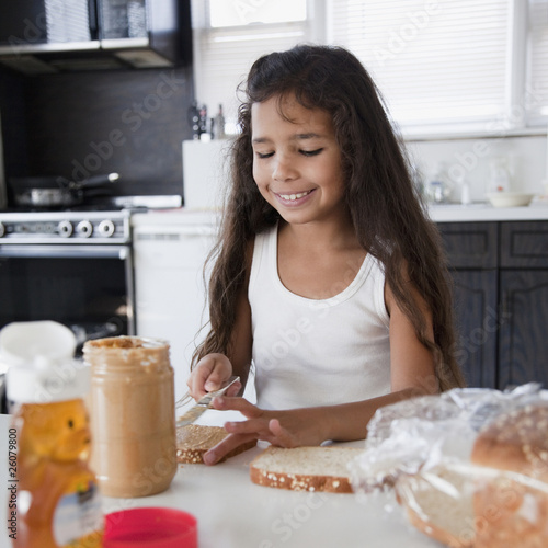 Photo: Hispanic girl making peanut butter sandwich Hispanic girl making peanut butter sandwich