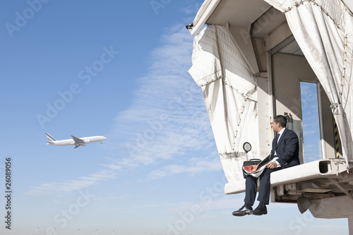 Foto: Hispanic businessman sitting on jetway Hispanic businessman sitting on jetway