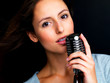 Young female star singer holding old fashioned microphone