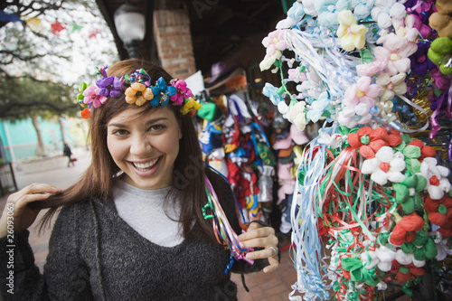 Photo: Mixed race woman trying on headdress at souvenir shop Mixed race woman trying on headdress at souvenir shop