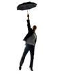Happy young business man holding an umbrella high up in air