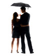 Happy young couple standing under umbrella