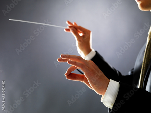 Photo: Orchestra conductor - Man directing with his baton in concert Orchestra conductor - Man directing with his baton in concert