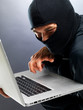 Cyber crime - Male hacker stealing information from laptop