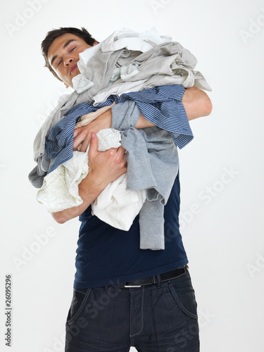 Photo: Washday - Young man looking tired doing laundry Washday - Young man looking tired doing laundry