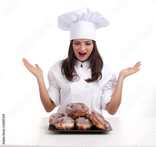 Photo: female chef in white uniform and hat with donuts female chef in white uniform and hat with donuts