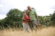 A senior couple carrying a blanket and a picnic basket
