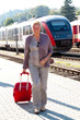 Ältere Seniren Frau am Bahnhof. Reisen in den Urlaub