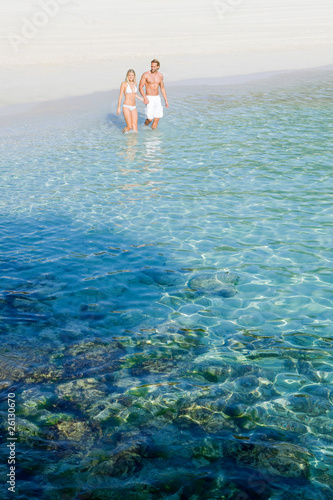 Photo: Couple walking beside the Ocean Couple walking beside the Ocean