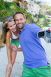 Photo: Young couple taking picture of themselves on beach Young couple taking picture of themselves on beach