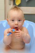 Cute boy brushing teeth in bath