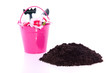 garden soil and equipment in a pink bucket isolated over white