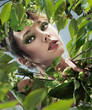 Portrait of pretty young girl among leaves