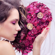 Portrait of a young beauty with rose heart
