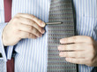 Man attaching a tie bar to his necktie