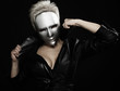 gloomy woman in silver mask posing on a black background