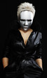 gloomy woman in silver mask posing on a black background