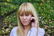 a young girl on nature speaks by phone