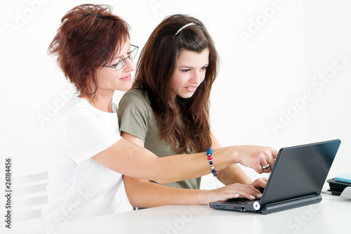 Photo: mother helping teen daughter with homework on laptop mother helping teen daughter with homework on laptop