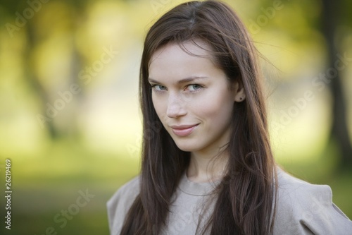 Photo: beautiful woman close-up portrait with nature background beautiful woman close-up portrait with nature background