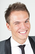 A young businessman, looking satisfied, giving a wink A young businessman, looking satisfied, giving a wink