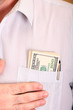 Close up of a shirt with one hundred dollar banknotes