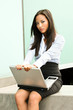Woman on laptop outside in the city