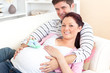 Portrait of a caucasian pregnant woman holding baby shoes and of